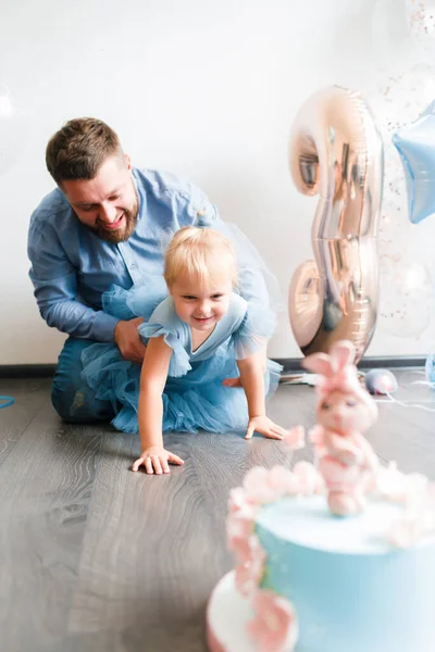Far och dotter firar sin dotters födelsedag. Födelsedag firande i blå klänningar och ballonger. — Stockfoto