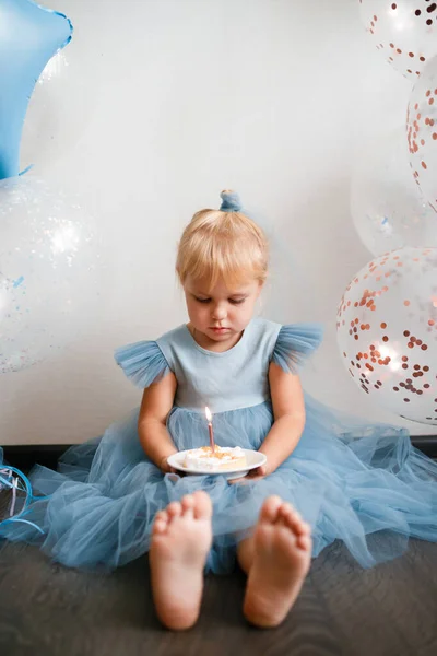 Mała blondynka zdmuchnęła świeczki na torcie urodzinowym. — Zdjęcie stockowe