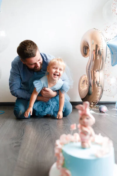 Otec a Dauther slaví narozeniny své malé dcery. Narozeninová oslava v modrých šatech a balónech. — Stock fotografie