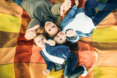 Mutlu bir aile gülümsüyor ve yukarı bakıyor. Aile piknikte.