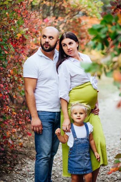 Mladá krásná rodina s malou blond dceru v džínových šatech. — Stock fotografie