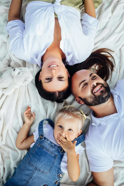 Young beautiful family with a little blonde daughter in denim clothes. — Stock Photo, Image