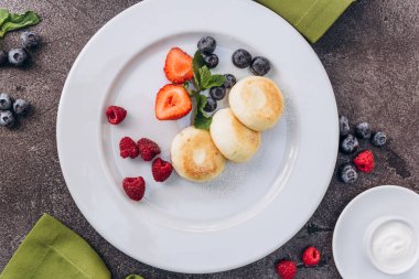 Nutritious vegetarian breakfast with cheesecakes and berries. 