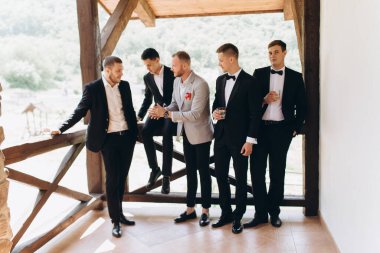 Damat ve arkadaşları düğünü kutluyorlar. Takım elbiseli adamlar. Erkeklerin duyguları ve dostluğu.