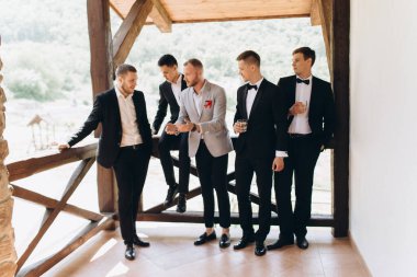 Damat ve arkadaşları düğünü kutluyorlar. Takım elbiseli adamlar. Erkeklerin duyguları ve dostluğu.