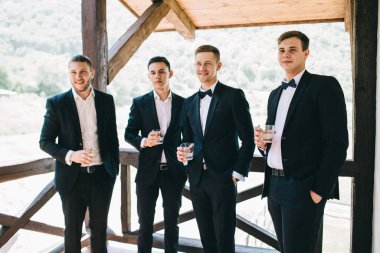 Damat ve arkadaşları düğünü kutluyorlar. Takım elbiseli adamlar. Erkeklerin duyguları ve dostluğu.
