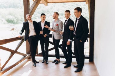 Damat ve arkadaşları düğünü kutluyorlar. Takım elbiseli adamlar. Erkeklerin duyguları ve dostluğu.