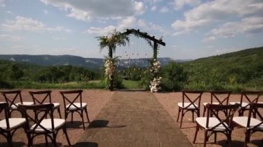 Boho stilinde düğün kemeri Parkta beyaz çiçekler ve ampuller.