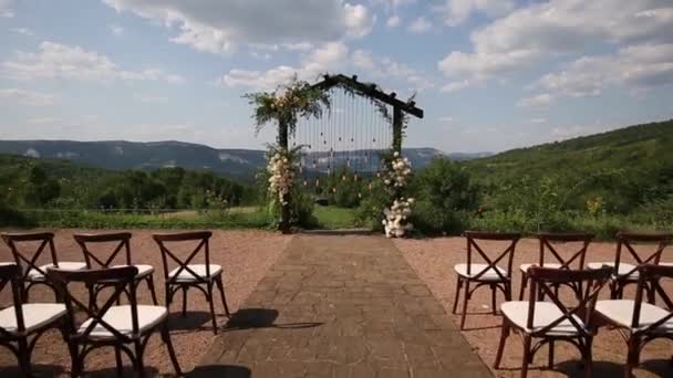 Wedding arch on boho style with white flowers in park with light bulbs. — Stock Video