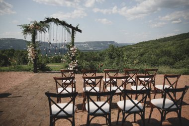 Boho stilinde düğün kemeri Parkta beyaz çiçekler ve ampuller.