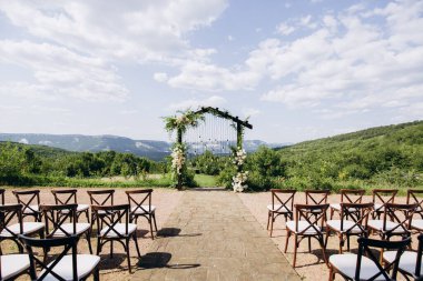 Rustuc tarzında düğün kemeri Parkta beyaz çiçekler ve ampuller.