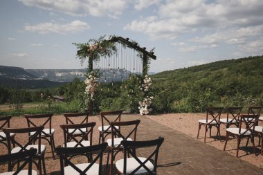 Beyaz ve çiçeklerle süslenmiş bir tören için kırsal düğün kemeri.