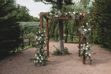 Beyaz ve çiçeklerle süslenmiş bir tören için kırsal düğün kemeri.