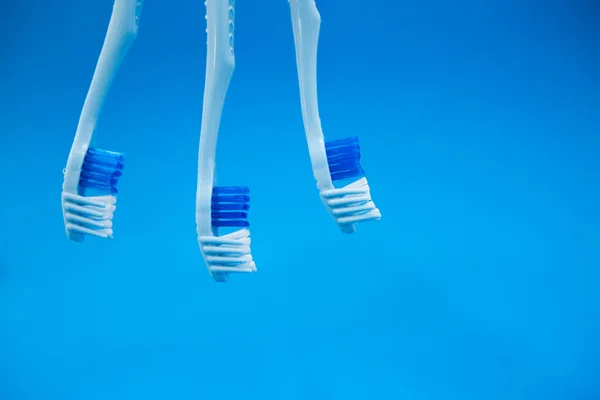 Μπλε οδοντόβουρτσες σε μπλε φόντο. Προστασία των δοντιών από τερηδόνα. — Φωτογραφία Αρχείου
