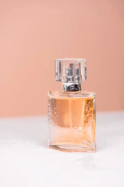 women\'s perfume on a white table and pink background. beauty and fragrance concept.