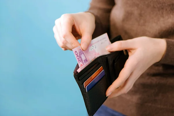 Bir Kadın Ukrayna Hryvnia Parasını Mavi Arka Plandaki Bir Çantadan — Stok fotoğraf