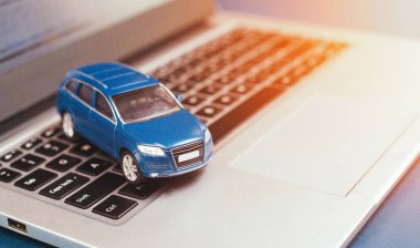Çevrimiçi açık artırma, sigorta ve satış arabasının sembolü. Mavi oyuncak SUV araba ve laptop. taşımacılık, kiralama, satma ve satın alma gibi araba işi kavramları.