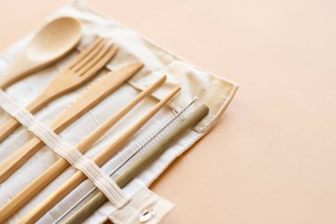 Bej arka plan, alternatif aksesuar, sıfır atık ve plastiksiz konsept üzerinde yeniden kullanılabilir çevre dostu Bambu çatal bıçak seti.