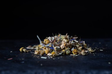 Siyah arka planda papatya çayı. Siyah beton bir tezgahta yalıtım.