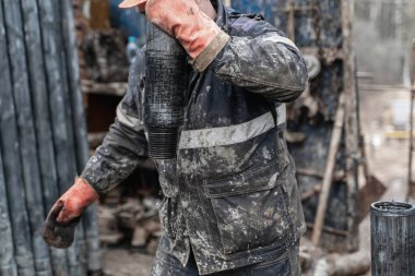 Offshore petrol kuyusu işçisi kuyu başındaki petrol kuyusunda delik açmak için alet ve ekipman hazırlayın. Sondaj borusu bağlantısı kuruyorum. Tribünlerin arasından matkap borusu bağlantısı için bir görünüm