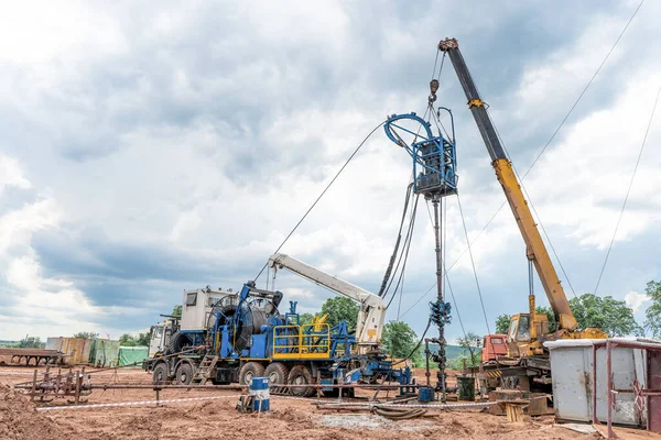 Coiled tubing unit doing well clean out. Wireline equipment hanging from top drive ready to be lowered downhole for logging.