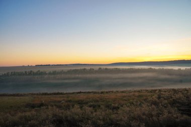 Sisli bir bahar gününde tahıl tarlasında gün doğumu. Kırsal alan, şafak vakti kırsal alan.