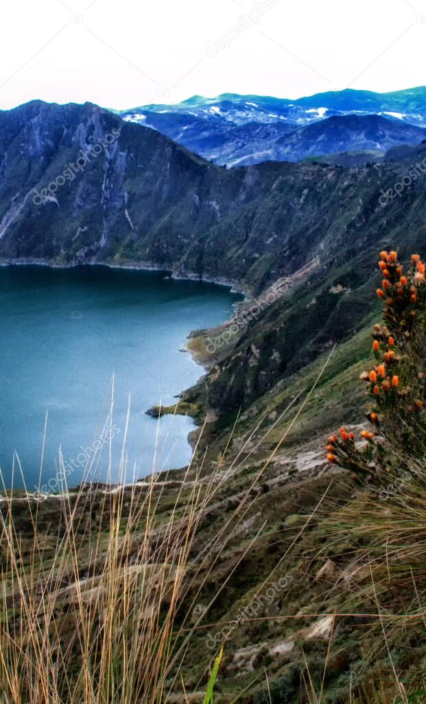 It is a 3 km wide water-filled caldera and the most western volcano in the Ecuadorian Andes. Amazing views, turquoise water. Laguna Quilotoa is a tourist site of growing popularity. orange flowers in the foreground. Breathtaking views, Must see in Ec