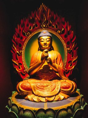 Çin Mahallesi 'ndeki Buda Dişi Kalıntısı Tapınağı. Yakından bakınca, yeşil nilüfer çiçeğinin üzerinde oturan Buda heykelini öğretirken hafifçe gülümserken el işaretleri gösteriyor. Kırmızı alevler arkada..