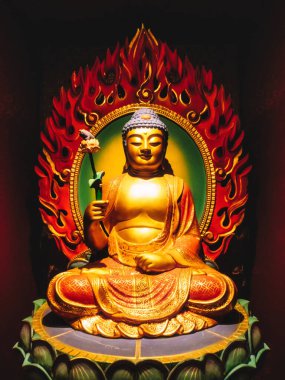 Çin Mahallesi 'ndeki Buda Dişi Kalıntısı Tapınağı. Yakından bakınca, yeşil nilüfer çiçeğinin üzerinde oturan Buda heykelini öğretirken hafifçe gülümserken el işaretleri gösteriyor. Kırmızı alevler arkada..