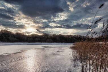 Doğal kış orman manzarası Gün batımında donmuş göl
