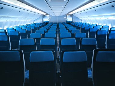 Mavi koltuklu ticari uçak kabini..