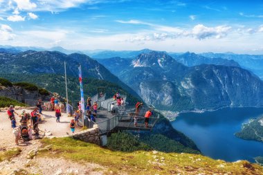 Obertraun, Avusturya - 12 Ağustos 2021: Alplerdeki en muhteşem izleme platformu üzerinde beş parmaklı turistler. Yaklaşık 400 m (1200 ft) derinliğinde bir uçurumun üzerine inşa edilmiştir..