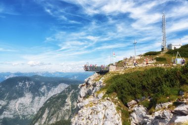 Obertraun, Avusturya - 12 Ağustos 2021: Alplerdeki en muhteşem izleme platformu üzerinde beş parmaklı turistler. Yaklaşık 400 m (1200 ft) derinliğinde bir uçurumun üzerine inşa edilmiştir..