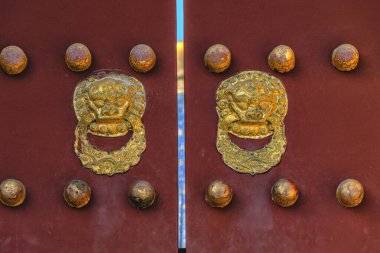 Antik kırmızı kapı yaldızlı Çıtçıt ve aslan baş kapı tokmakları, cennet Tapınağı ile.