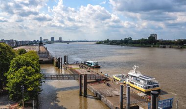 Antwerp, Belçika - 25 Ağustos 2024: Güneşli bir günde Scheldt Nehri 'nin karşısındaki teknelerin resmi.