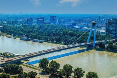 Bratislava şehir manzarasının Tuna Nehri üzerindeki SNP köprüsünün üzerindeki ünlü bir UFO kulesi gözlem güvertesiyle havadan görüntüsü. Bratislava Slovakya 'nın başkentidir..