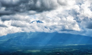 Japonya, Kawaguchiko 'daki tepelerin ve bulutların arkasındaki Fuji Dağı.
