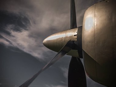 Old propeller airplane, vintage sepia black and white tone, against the sky background. Propeller and turbine detail