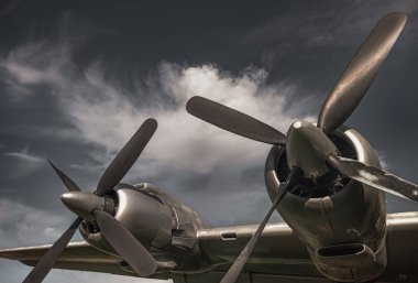 Old propeller airplane, vintage sepia black and white tone, against the sky background. Propeller and turbine detail