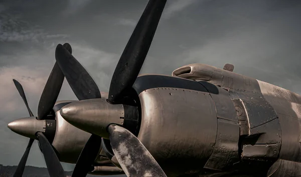 Old propeller airplane, vintage sepia black and white tone, against the sky background. Propeller and turbine detail