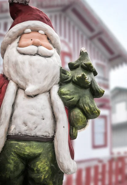 Renkli evlerle dolu Noel sahnesinde komik kardan adam, dikey