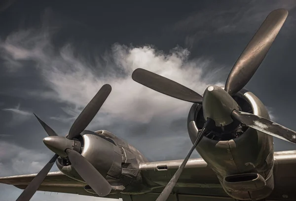 Old propeller airplane, vintage sepia black and white tone, against the sky background. Propeller and turbine detail