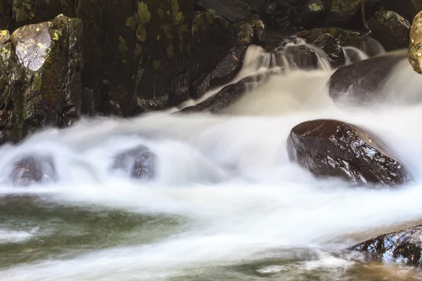 Vattenfall och stenar täckt av mossa — Stockfoto