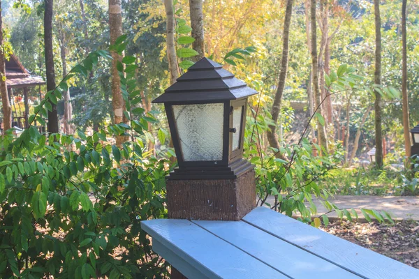 Lanterna no poste de madeira do banco de madeira — Fotografia de Stock