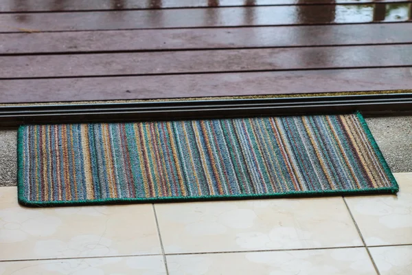 Doormat with open door — Stock Photo, Image