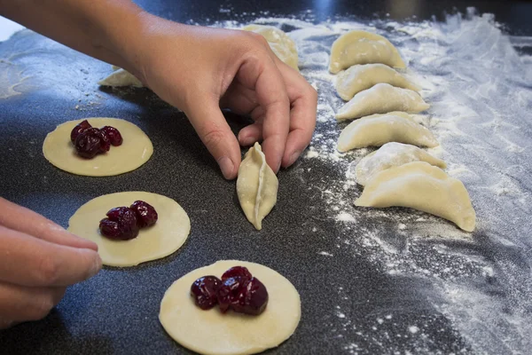 Kvinna skulpterar för hand dumplings med körsbär Royaltyfria Stockfoton