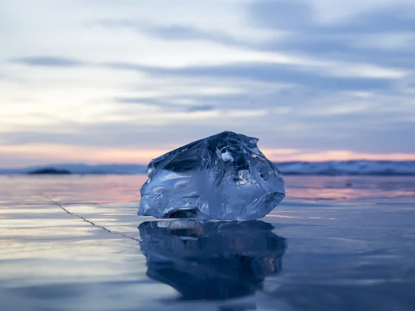 A piece of ice lying on the frozen surface of lake Baikal at daw — Stock Photo, Image