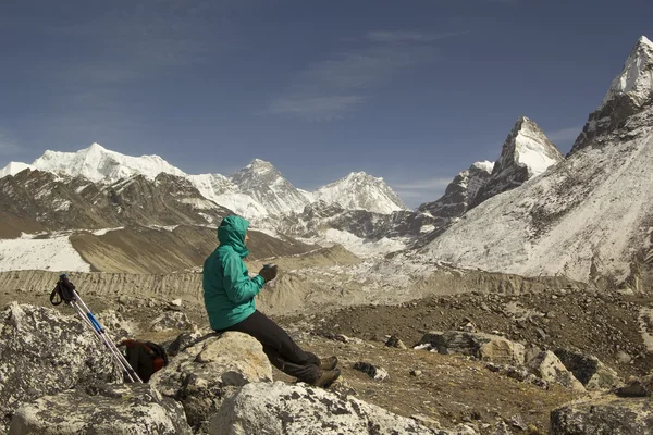 Trekker vrouw met een kopje thee op een steen zitten en genieten van — Stockfoto