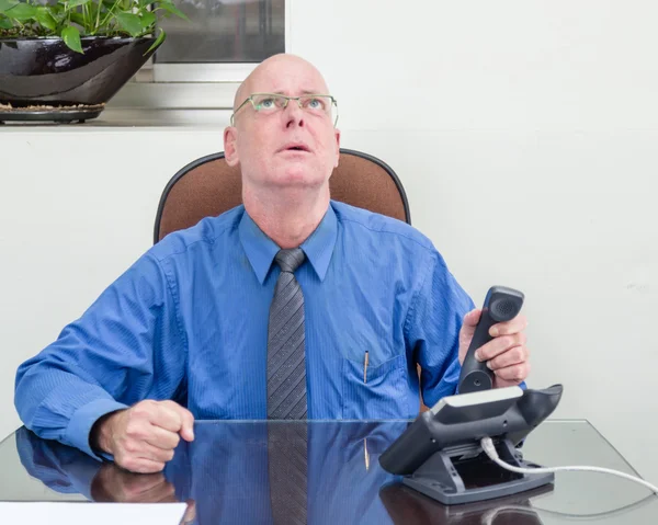Empresario al teléfono en el escritorio, frustrado — Foto de Stock