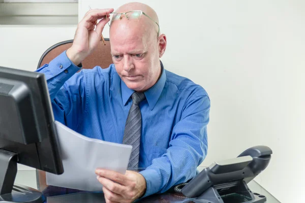 Ejecutivo que compara ordenador y notas escritas — Foto de Stock